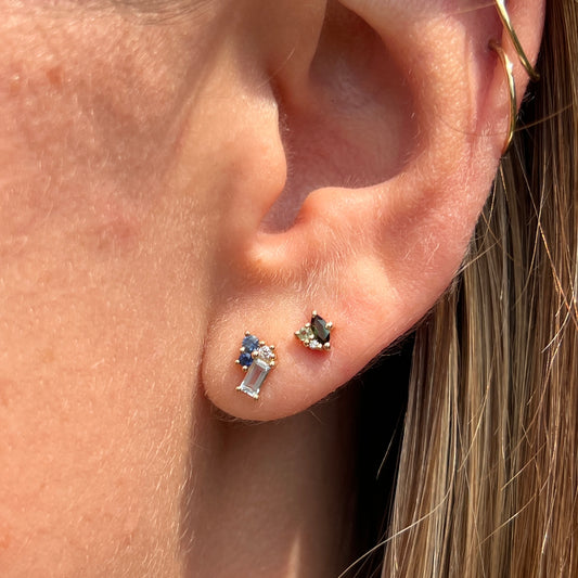 green tourmaline, perifot and diamonds cluster studs worn besides blue cluster studs set with blue topaz, sapphires and diamonds, shown on ear.