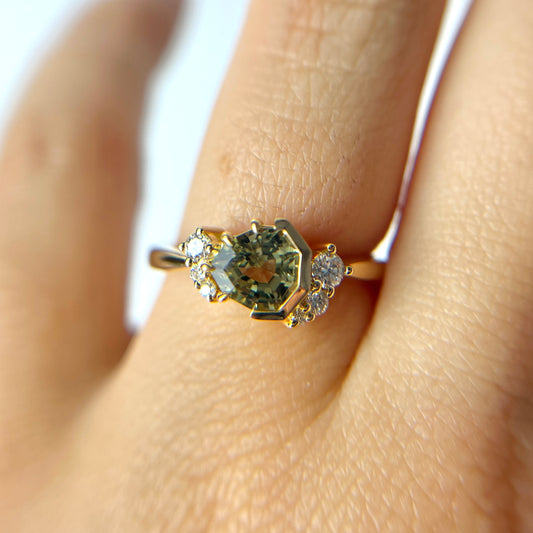 1.27ct unheated geometric trillion cut green Madagascar sapphire and diamond ring in 18k yellow gold, worn on hand showing stone colour and setting detail