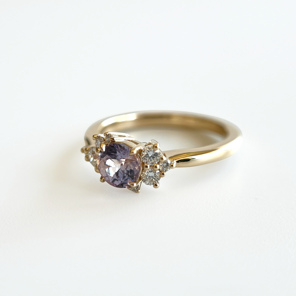 Bague de fiançailles en saphir violet clair et diamants en or jaune 14k, vue de côté montrant le serti asymétrique