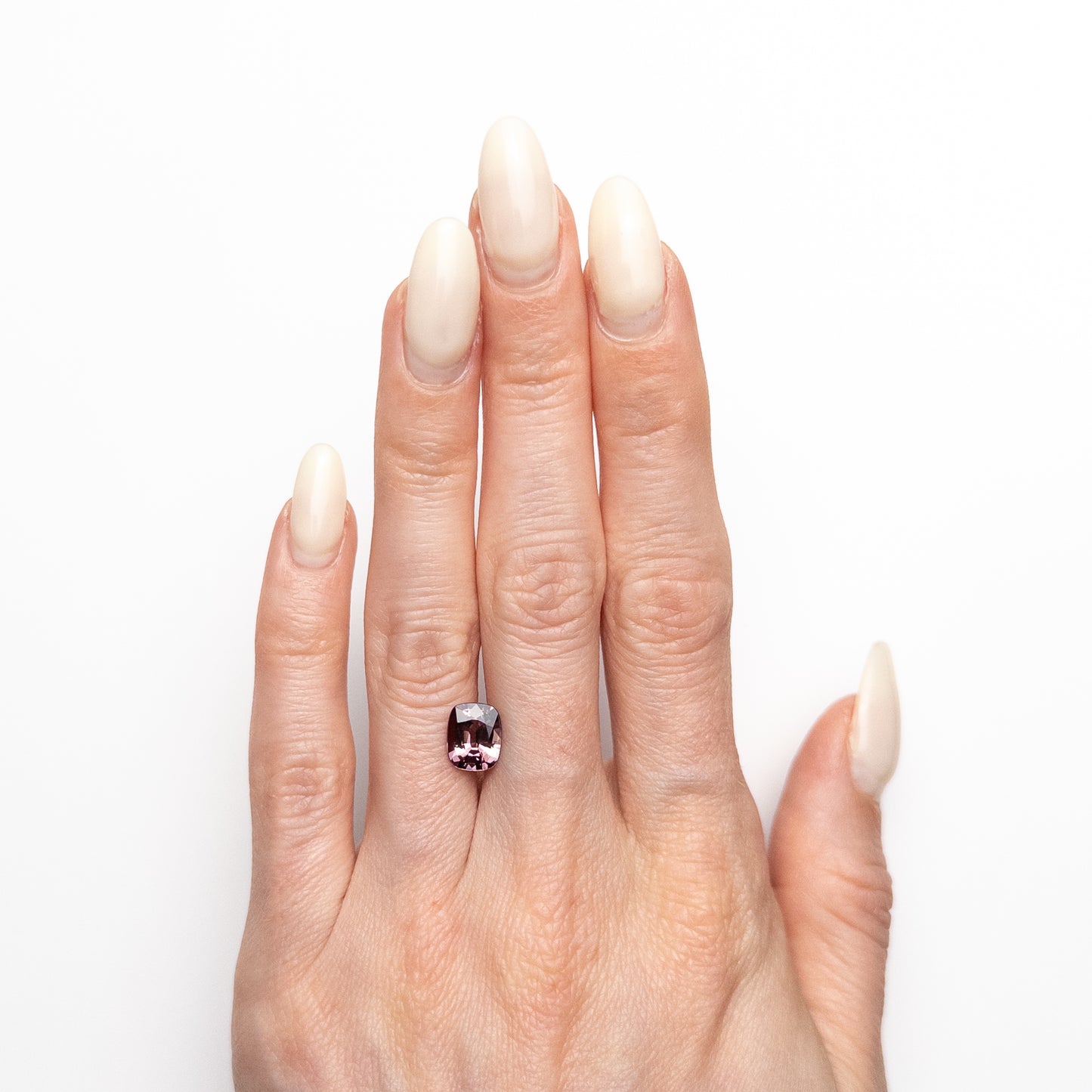 2.05ct unheated antique cushion cut brownish-pink sapphire from Madagascar, loose stone held on hand showing colour and cut, before setting