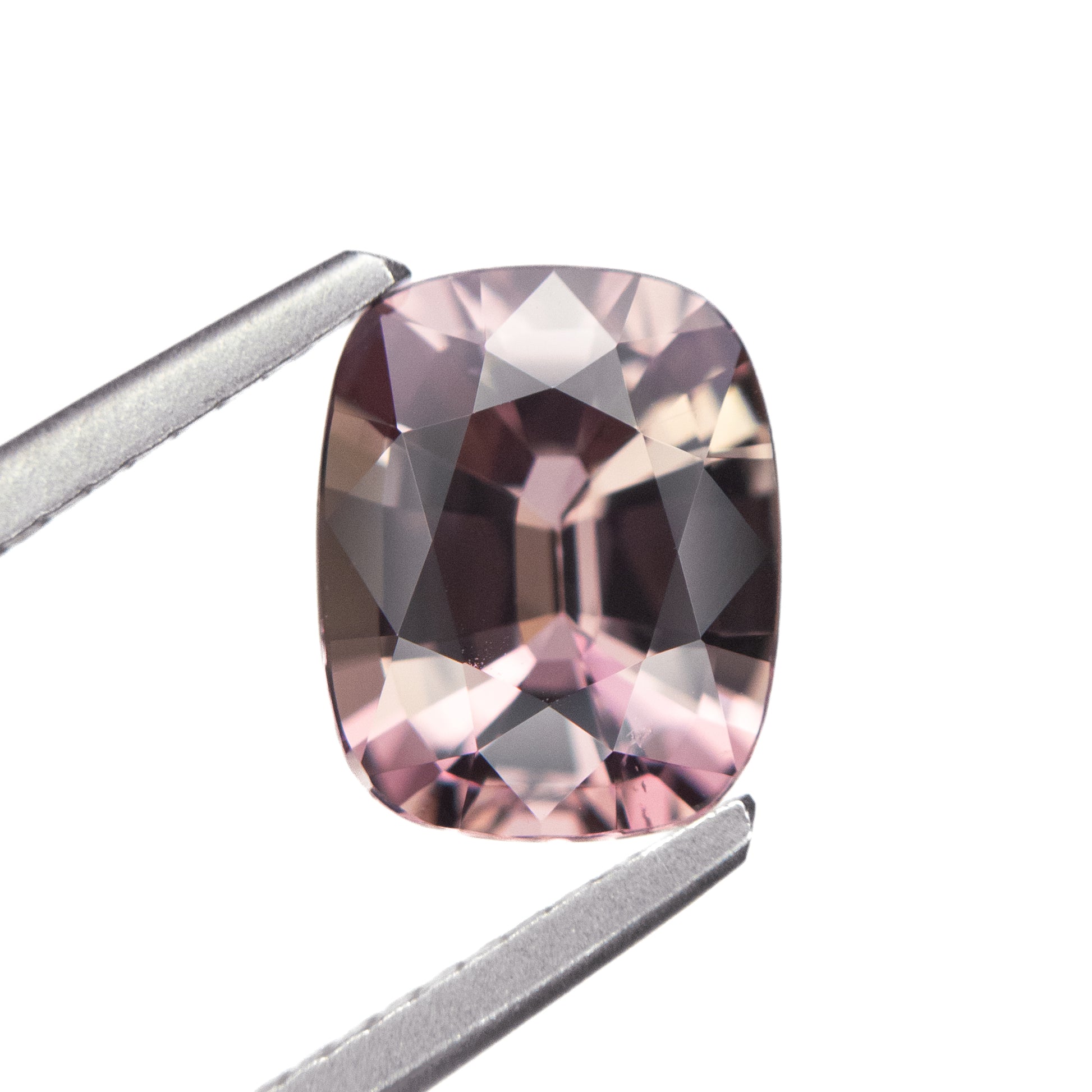 2.05ct unheated antique cushion cut brownish-pink sapphire from Madagascar, held in tweezers showing faceting and colour detail