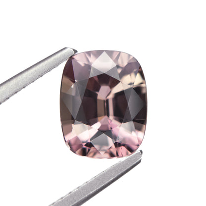 2.05ct unheated antique cushion cut brownish-pink sapphire from Madagascar, held in tweezers showing faceting and colour detail