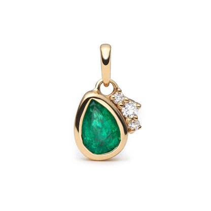 A gold pendant featuring a teardrop-shaped green emerald and a small cluster of diamond accents on the right side, set against a plain white background.