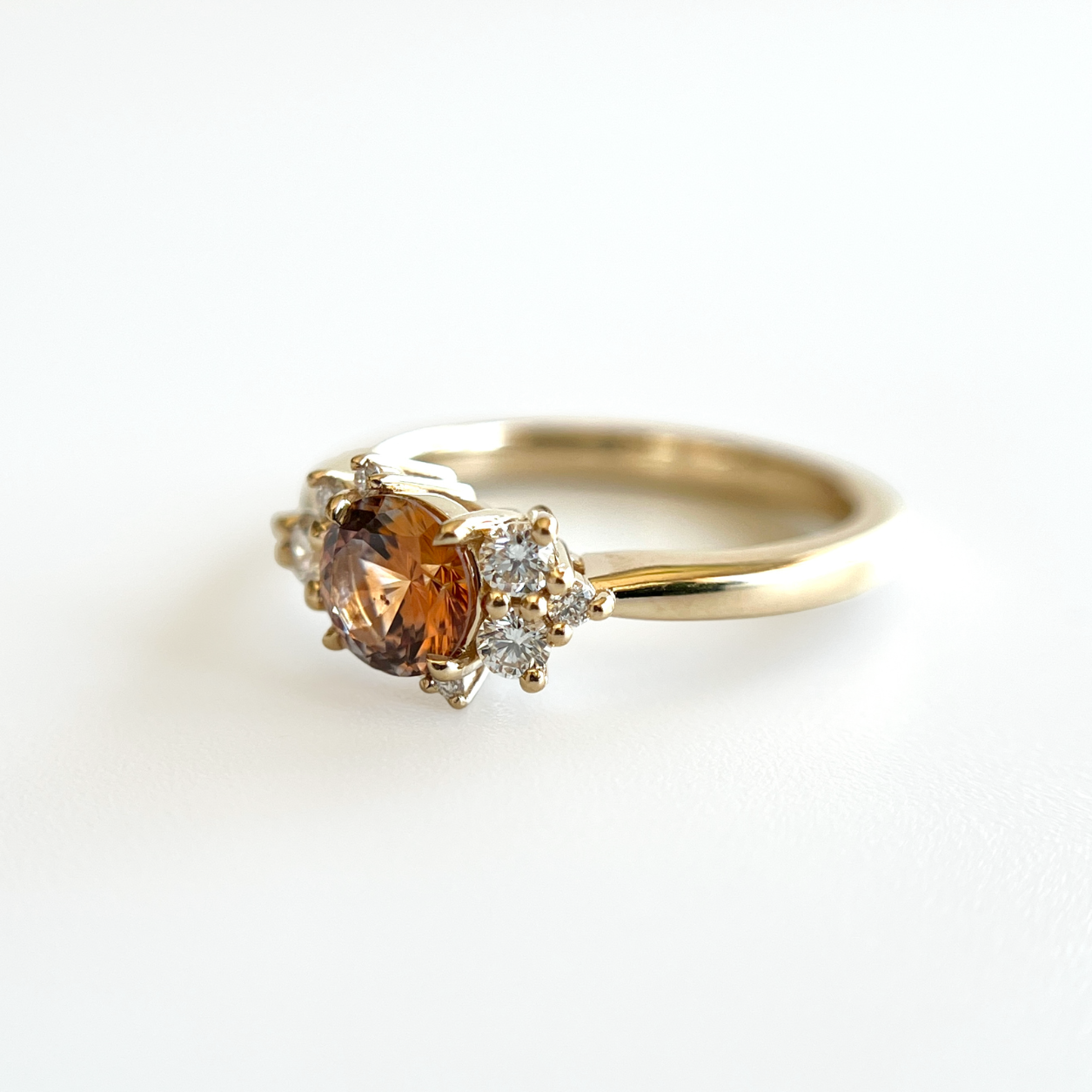 Bague de fiançailles en saphir Montana orange-rose et diamants en or jaune 14k, vue de côté montrant le profil du corps de bague et la hauteur du serti