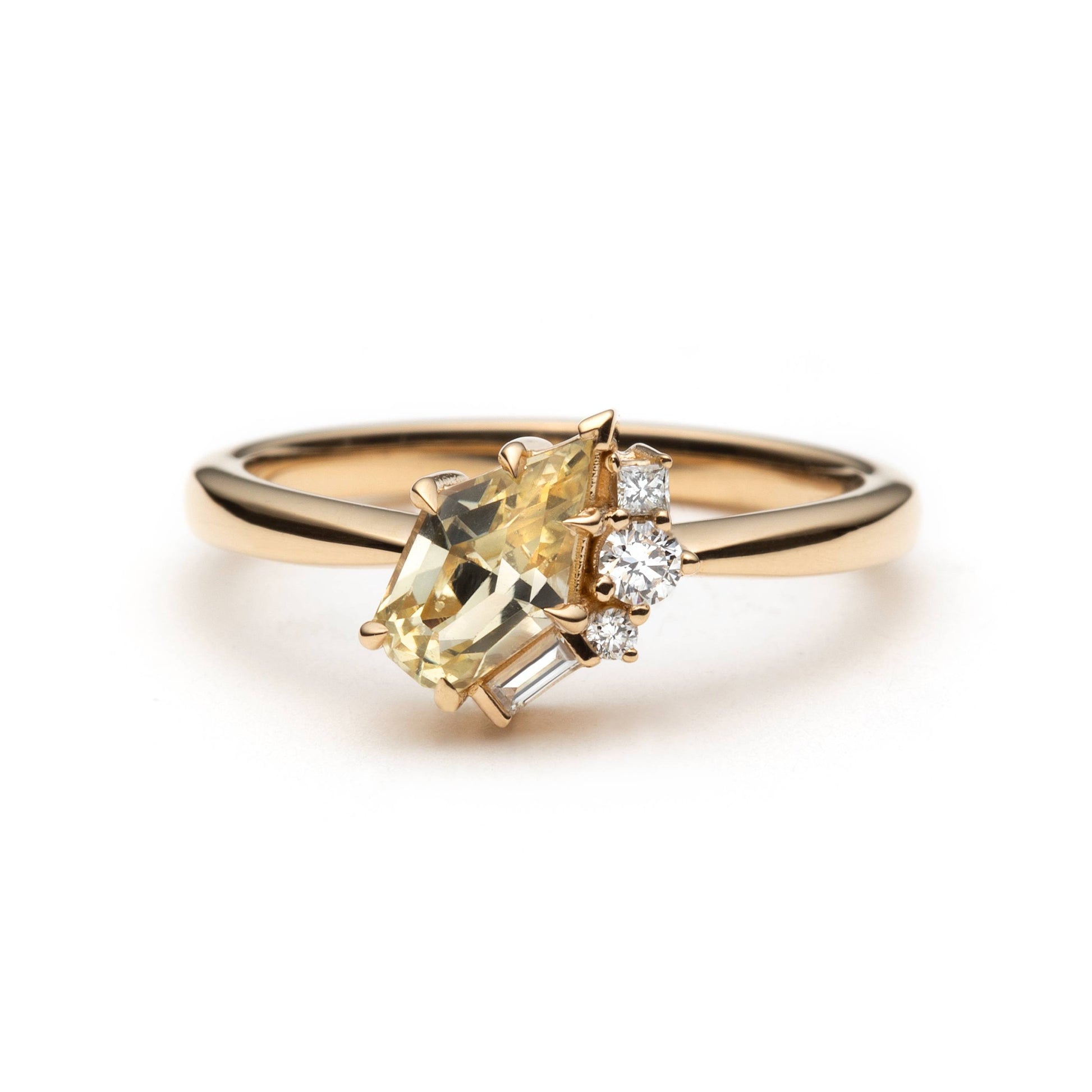 Light yellow shield-cut sapphire ring with eagle-claw setting and diamond accents