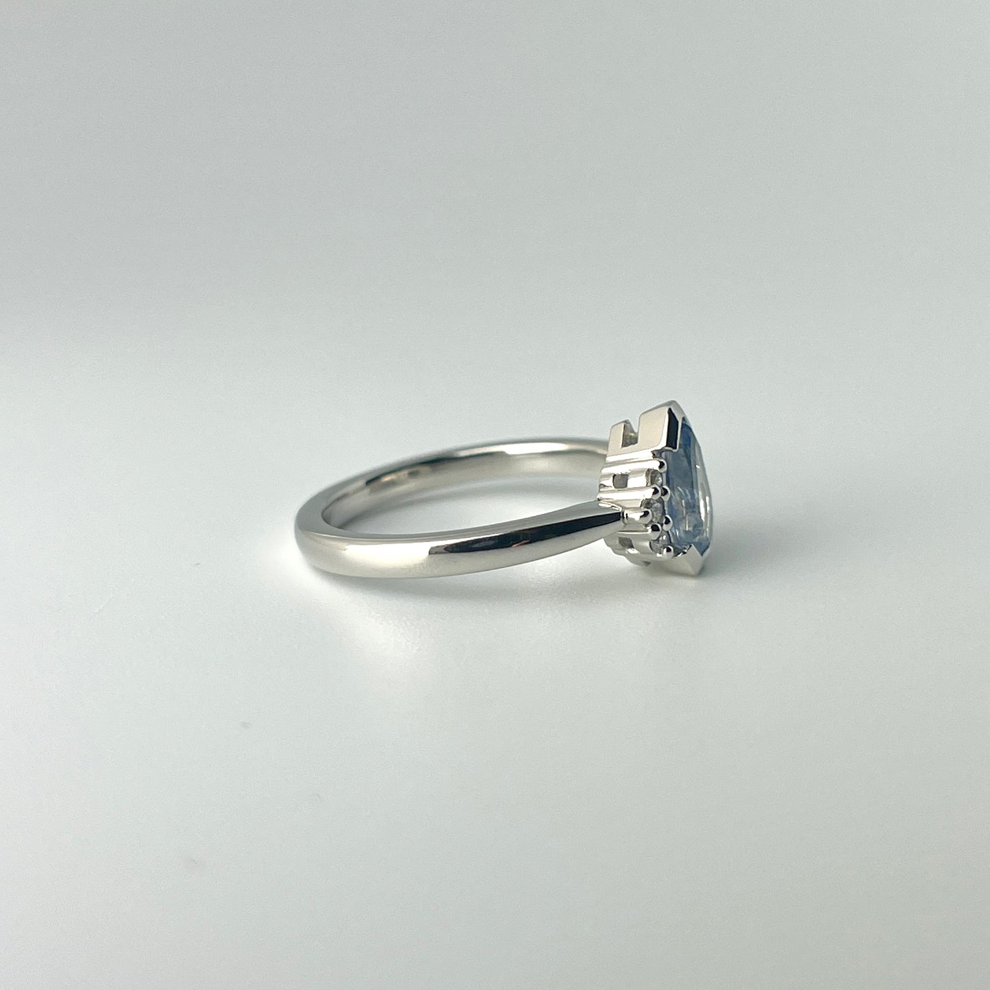 Platinum, blue sapphire and diamond ring, showing the low double gallery basket style head in a side view photo