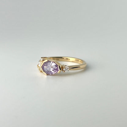 Step-cut pear purple sapphire engagement ring with asymmetric diamond accents in yellow gold