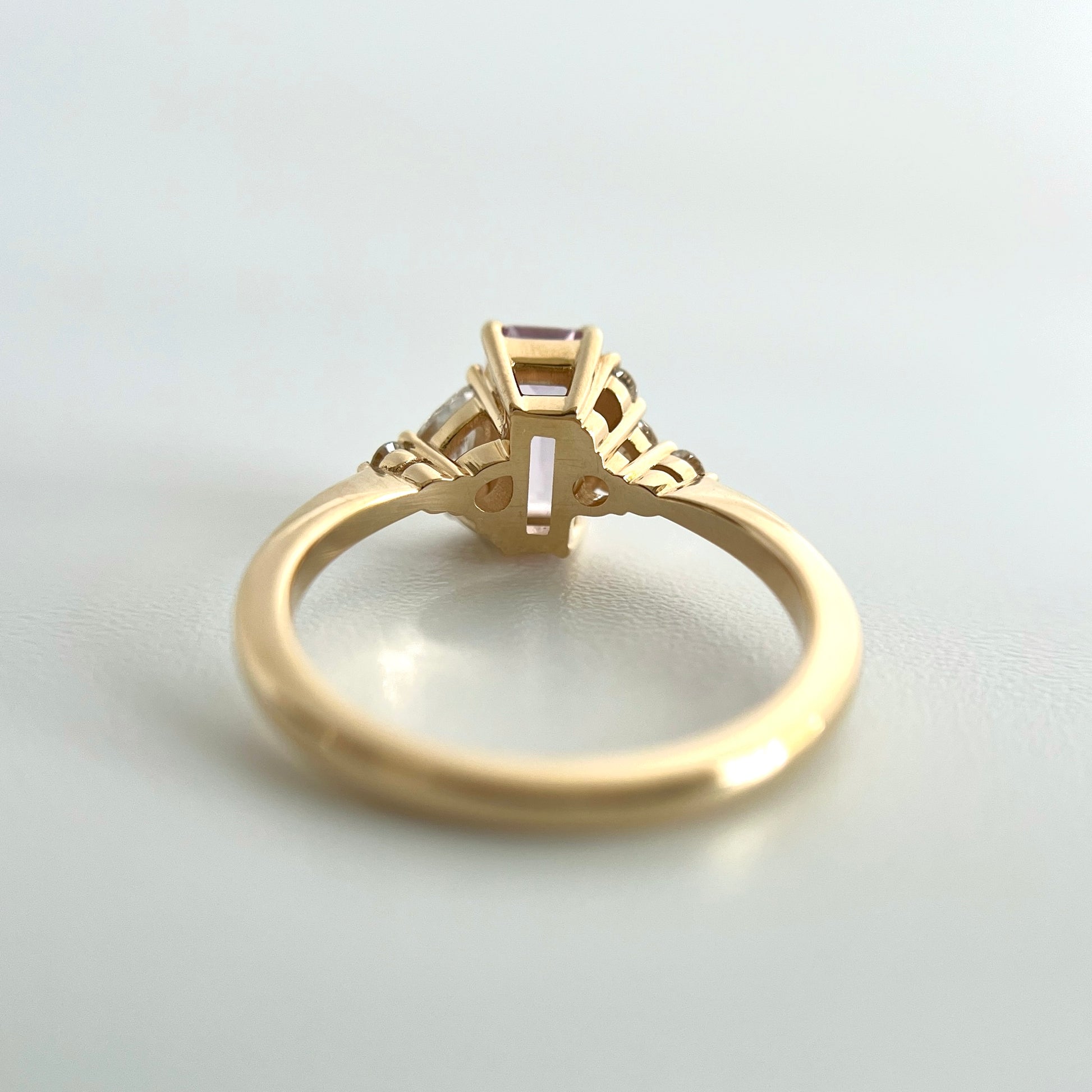 Underside view of a yellow gold ring, showcasing the double gallery detail of each setting. 