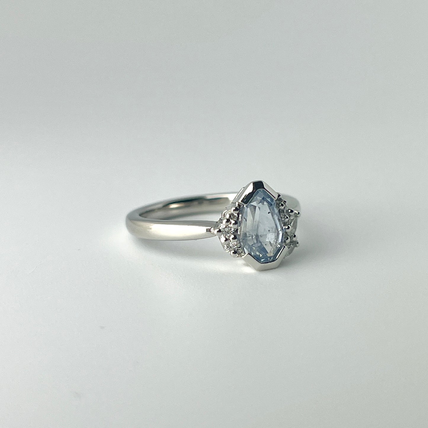 One-of-a-kind light blue sapphire engagement ring in platinum with asymmetrical diamond cluster