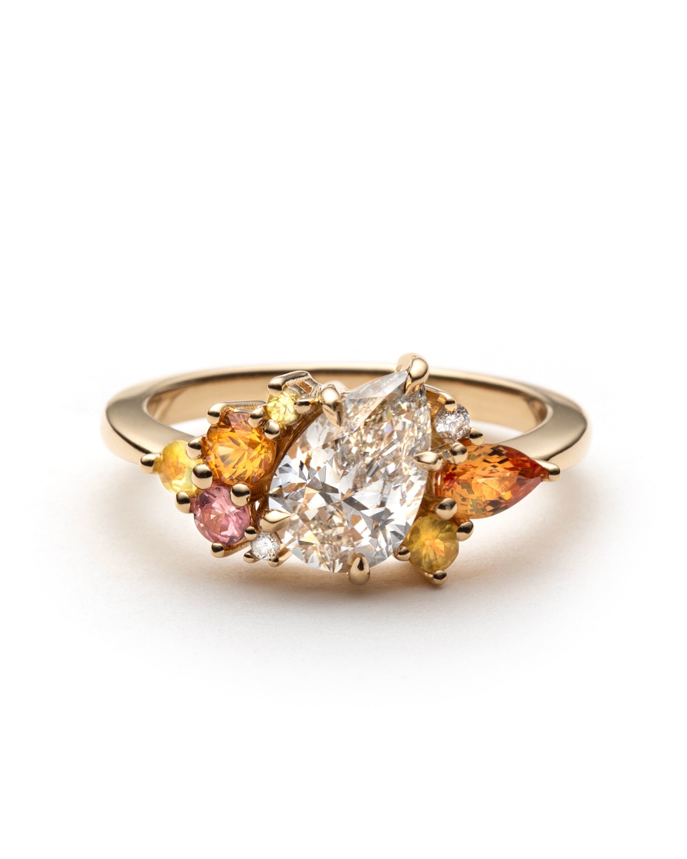 tilted champagne pear-shape canadian diamond and sapphire cluster ring set with apphires ranging from orange, yellow, to pink, all set in 18 yellow gold. 