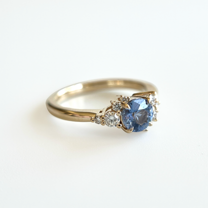 Bague de fiançailles en saphir bleu cornflower et diamants en or jaune 14k, vue en angle montrant le serti asymétrique
