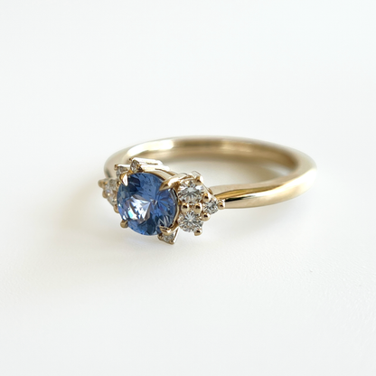 Bague de fiançailles en saphir bleu cornflower et diamants en or jaune 14k, vue de côté montrant le serti asymétrique
