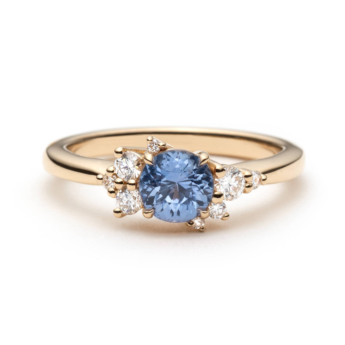 0.82ct round unheated cornflower blue Sri Lankan sapphire and diamond cluster engagement ring in 14k yellow gold, front view showing asymmetric diamond setting