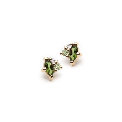 Green gemstone stud earrings in yellow gold featuring a cluster of marquise shaped green tourmalines, round peridots and diamonds. Earrings are shot on a white background. 
