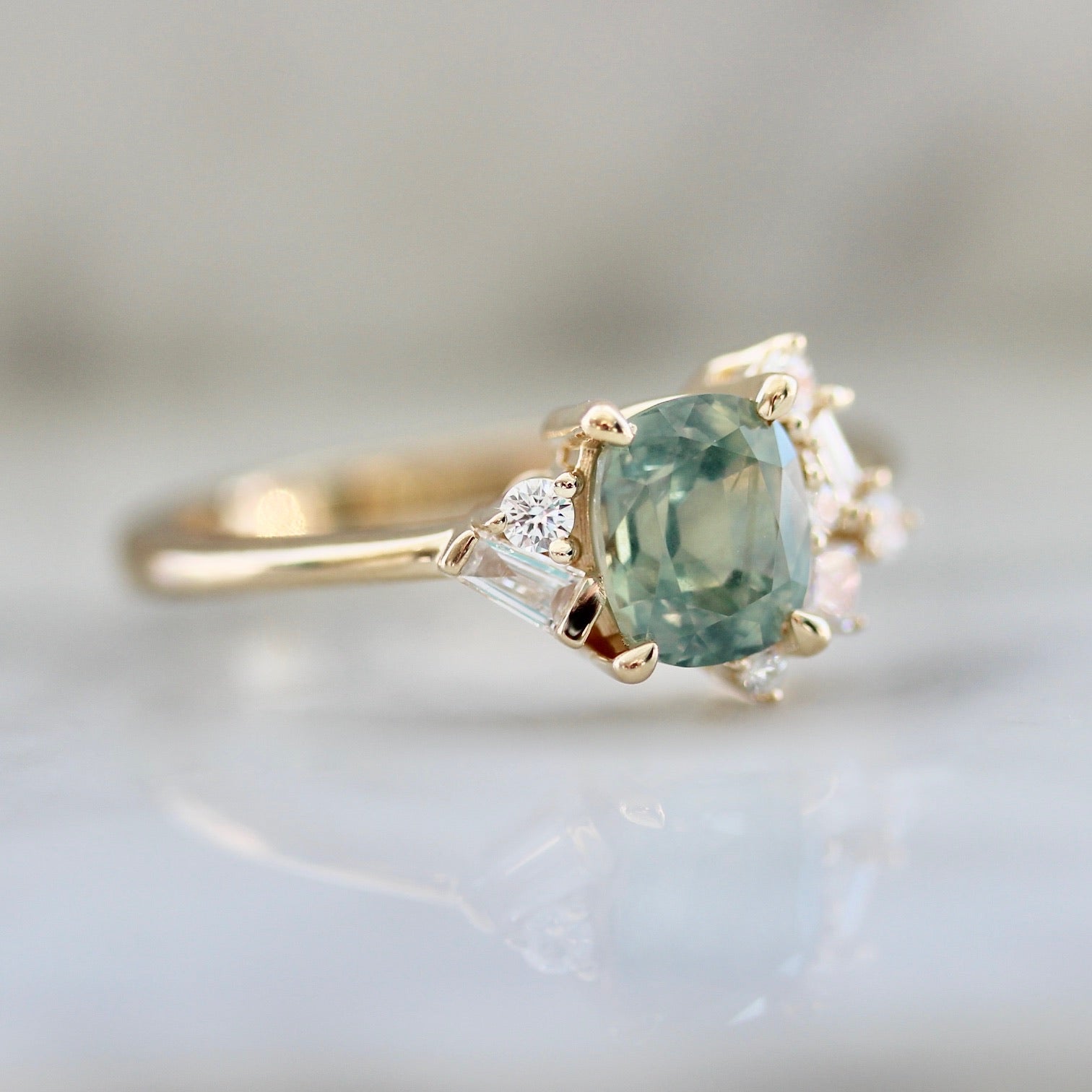 1.47ct unheated cushion cut green Montana sapphire and diamond cluster ring in 14k yellow gold, profile view showing band width and asymmetric diamond setting detail