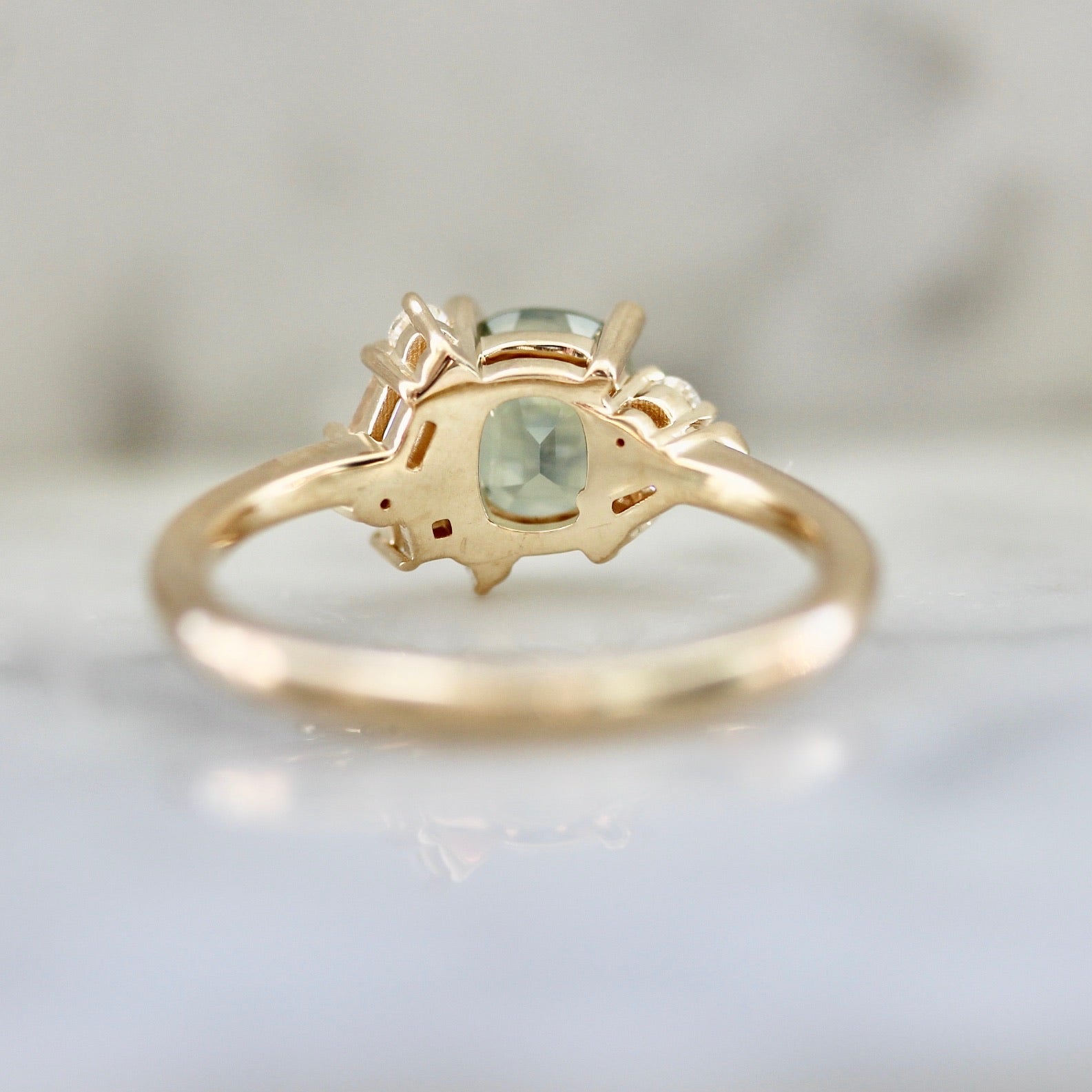 1.47ct unheated cushion cut green Montana sapphire and diamond cluster ring in 14k yellow gold, underside view showing setting construction and band detail