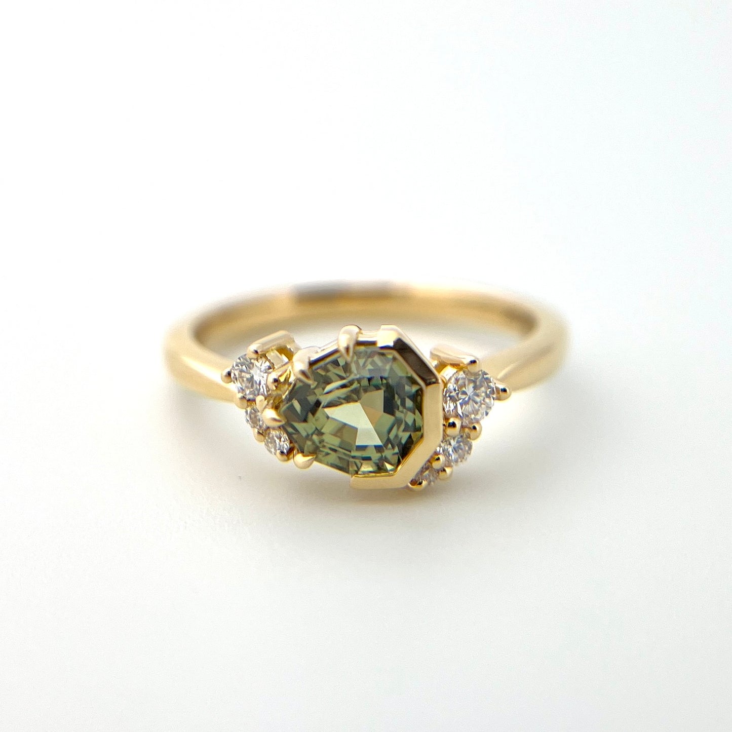 1.27ct unheated geometric trillion cut green Madagascar sapphire and diamond ring in 18k yellow gold, front view showing setting detail and band profile