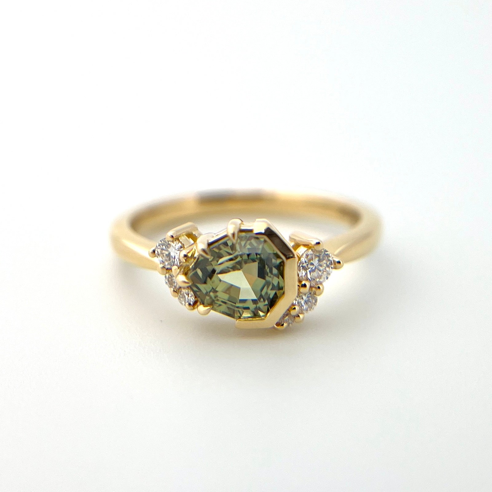 1.27ct unheated geometric trillion cut green Madagascar sapphire and diamond ring in 18k yellow gold, front view showing setting detail and band profile