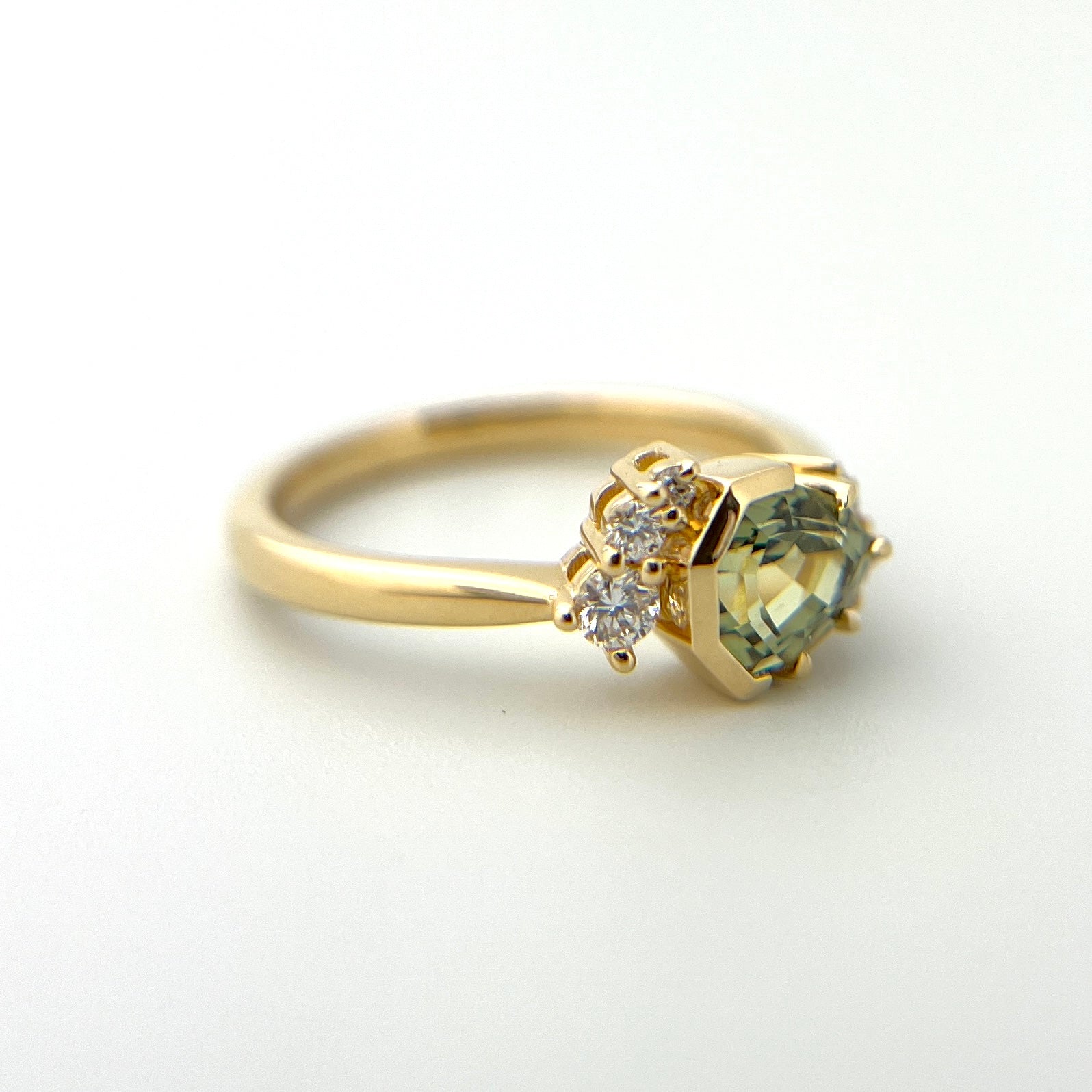1.27ct unheated geometric trillion cut green Madagascar sapphire and diamond ring in 18k yellow gold, profile view showing band width and half bezel setting detail