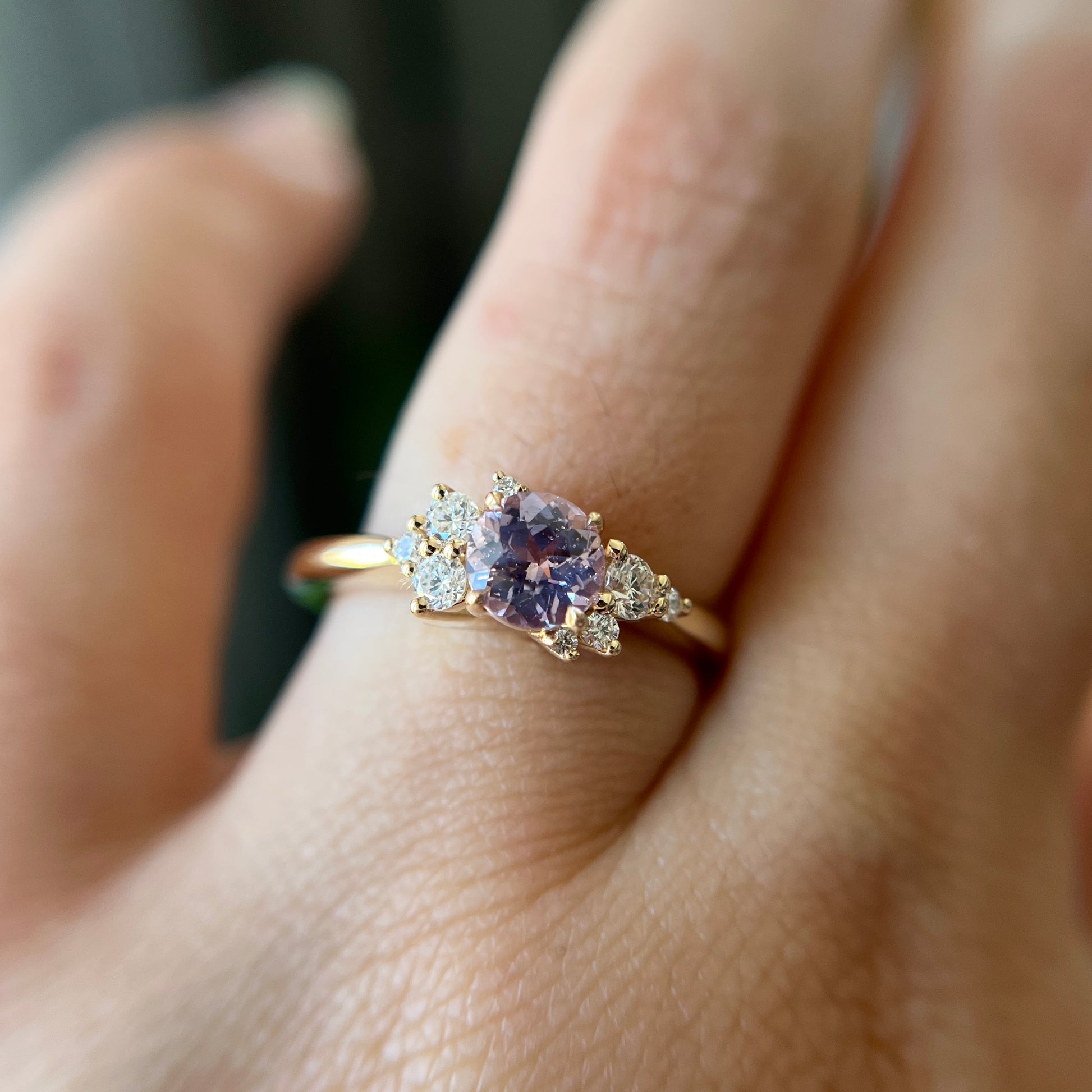 Bague de fiançailles en saphir violet clair et diamants en or jaune 14k, portée au doigt montrant la couleur de la pierre et le détail du serti