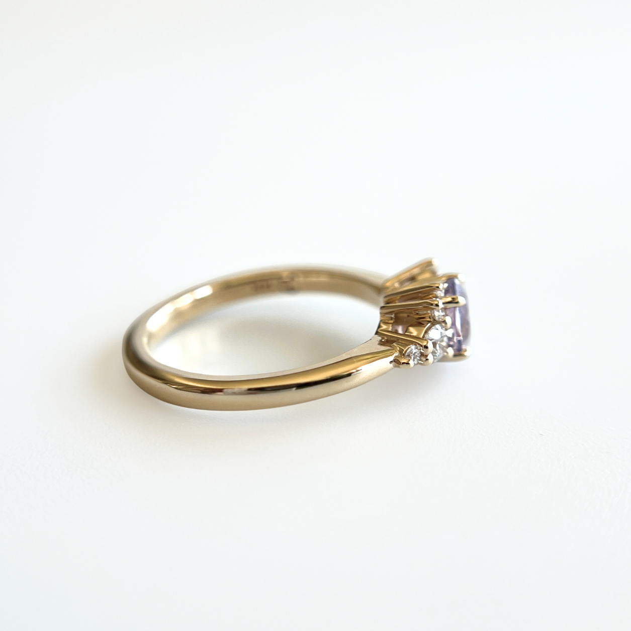 Bague de fiançailles en saphir violet clair et diamants en or jaune 14k, vue de profil montrant la largeur du corps de bague et la hauteur du serti