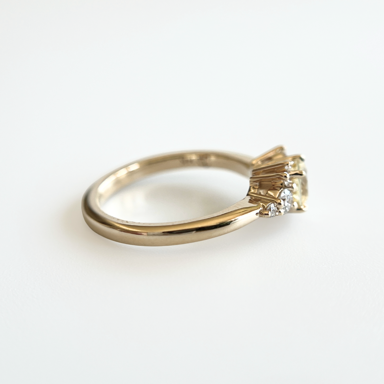 Bague de fiançailles en saphir jaune clair et diamants en or jaune 14k, vue de profil montrant la largeur du corps de bague et le détail du serti