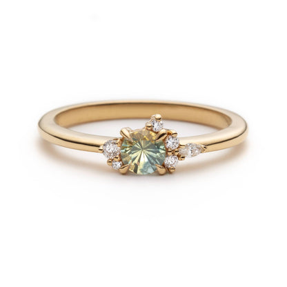 Bague de fiançailles en saphir bicolore rond de 0,36ct passant du jaune au bleu et diamants naturels en or jaune 14k, vue de face sur fond blanc montrant le changement de couleur de la pierre et le cluster asymétrique