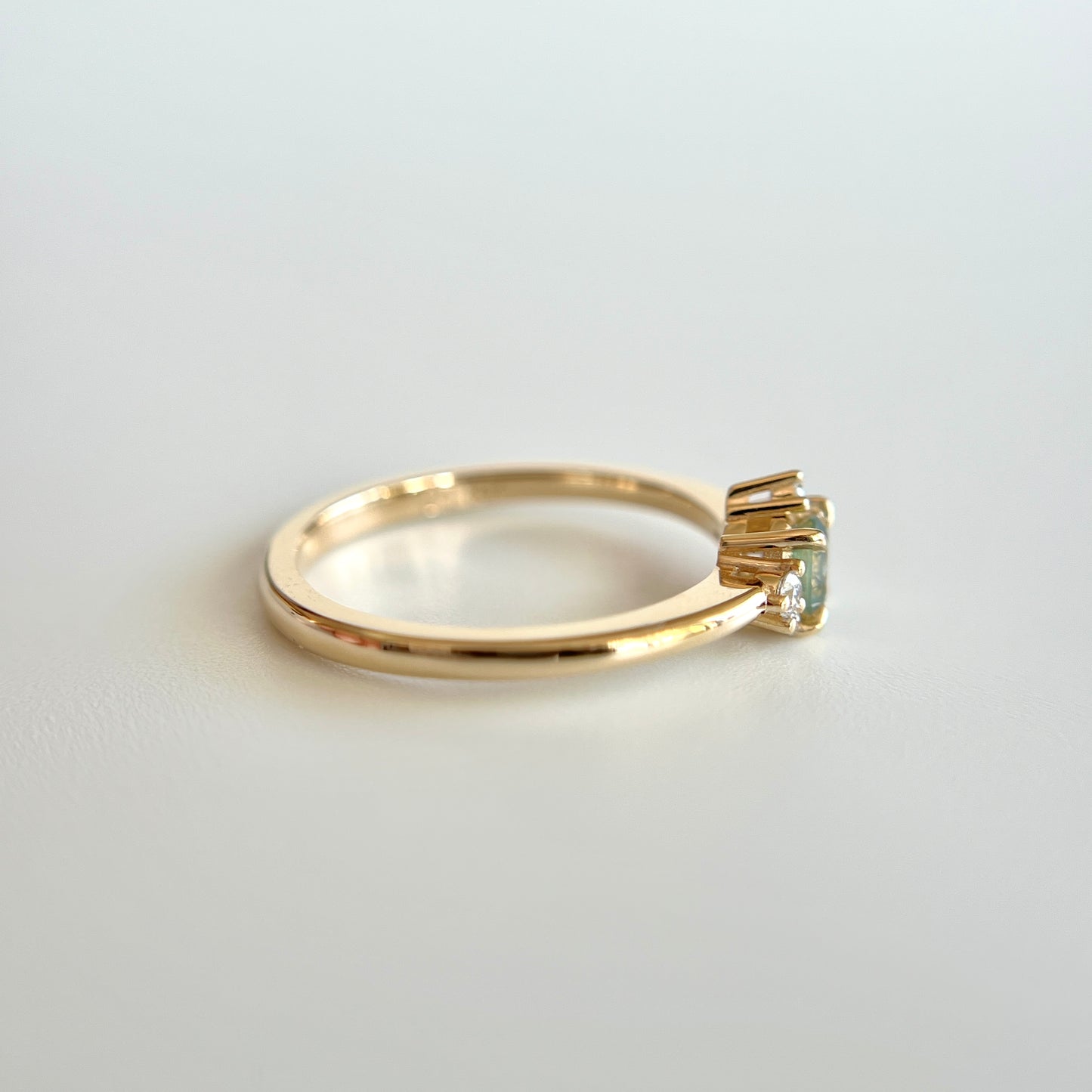 Bague de fiançailles en saphir bicolore rond de 0,36ct passant du jaune au bleu et diamants naturels en or jaune 14k, vue de côté montrant le profil du corps de bague et la hauteur du serti
