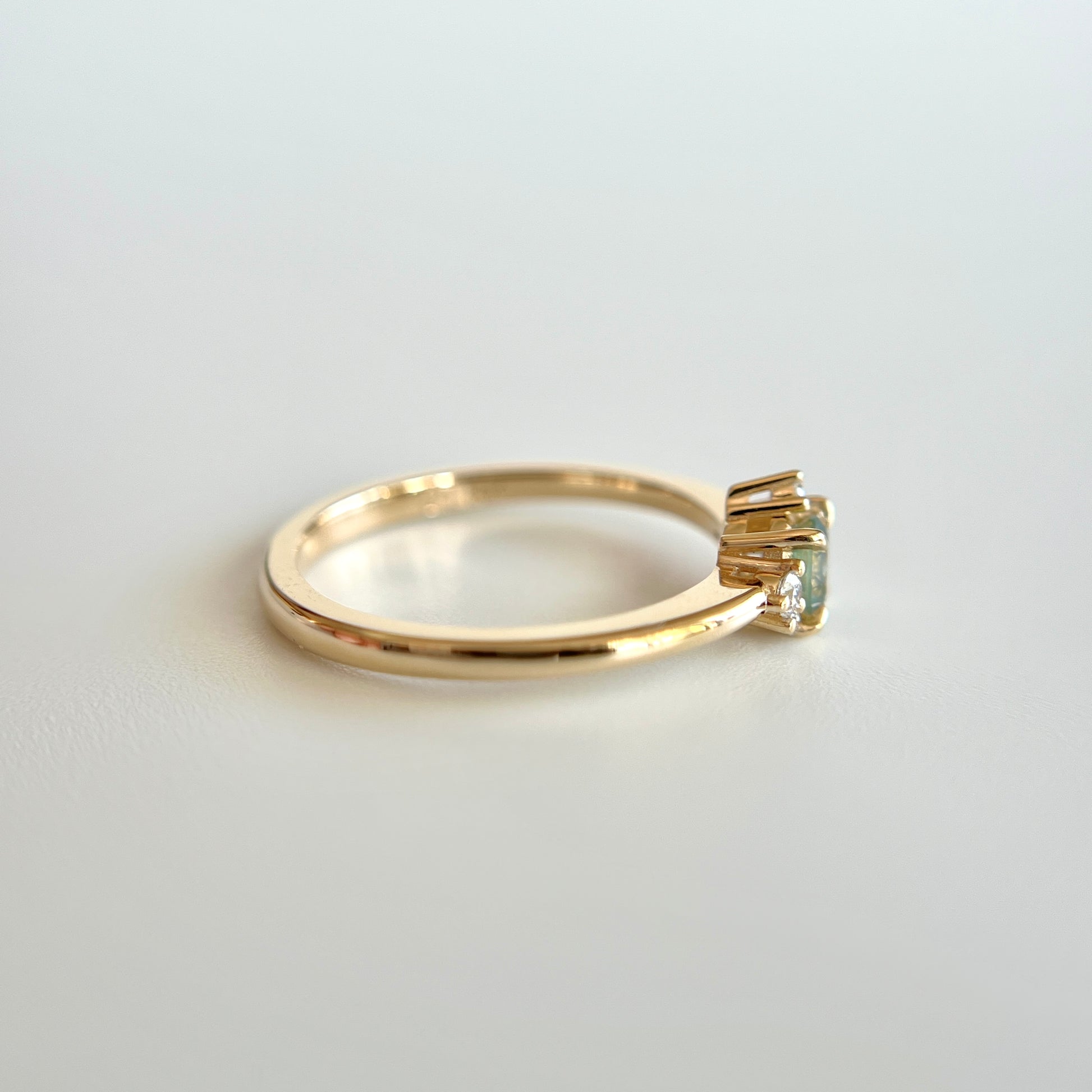 Bague de fiançailles en saphir bicolore rond de 0,36ct passant du jaune au bleu et diamants naturels en or jaune 14k, vue de côté montrant le profil du corps de bague et la hauteur du serti