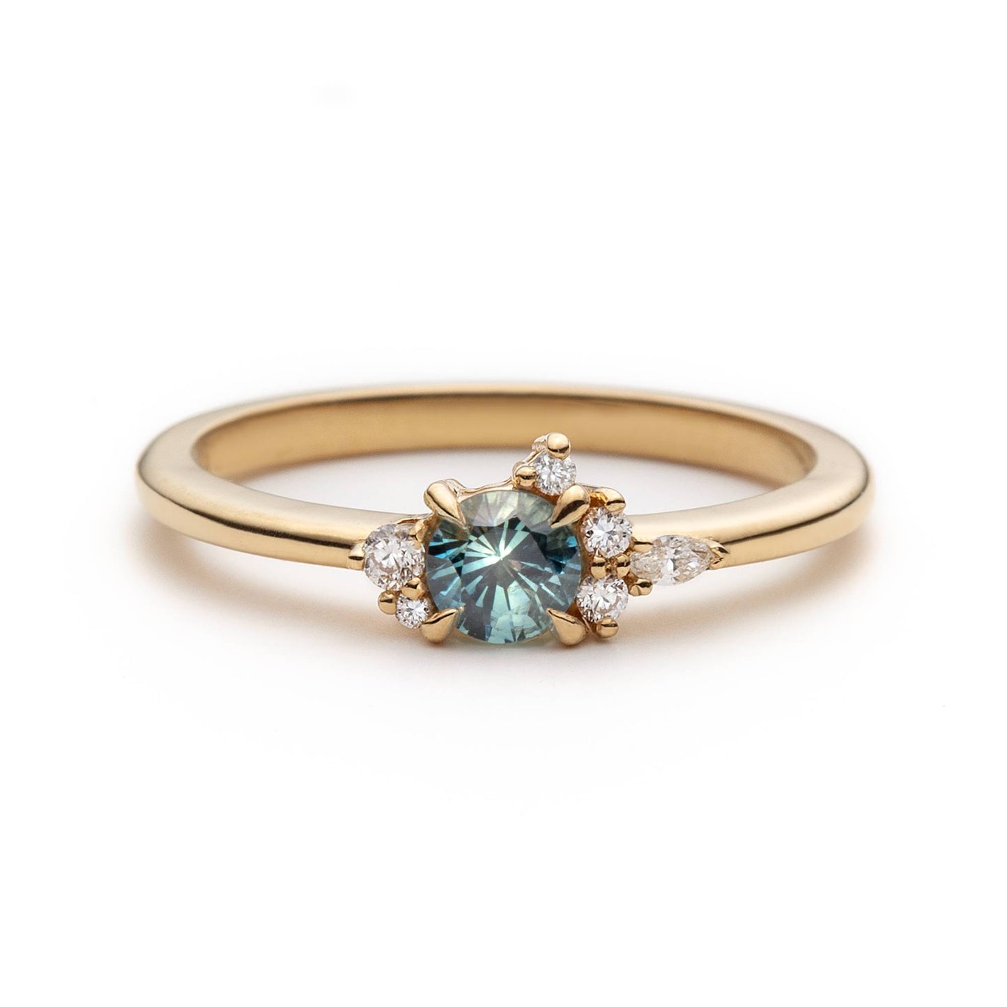 Bague de fiançailles en saphir sarcelle rond de 0,38ct et diamants naturels en or jaune 14k, vue de face sur fond blanc montrant la couleur de la pierre et le cluster asymétrique