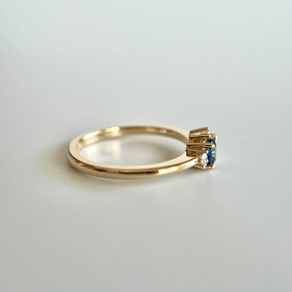 Bague de fiançailles en saphir sarcelle rond de 0,38ct et diamants naturels en or jaune 14k, vue de côté montrant le profil du corps de bague et la hauteur du serti