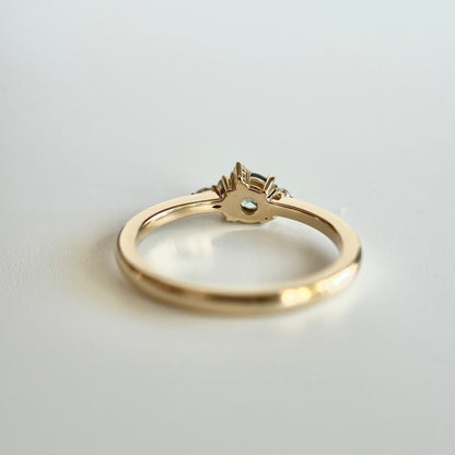 Bague de fiançailles en saphir sarcelle rond de 0,38ct et diamants naturels en or jaune 14k, vue du dessous montrant la construction du serti et le détail du corps de bague