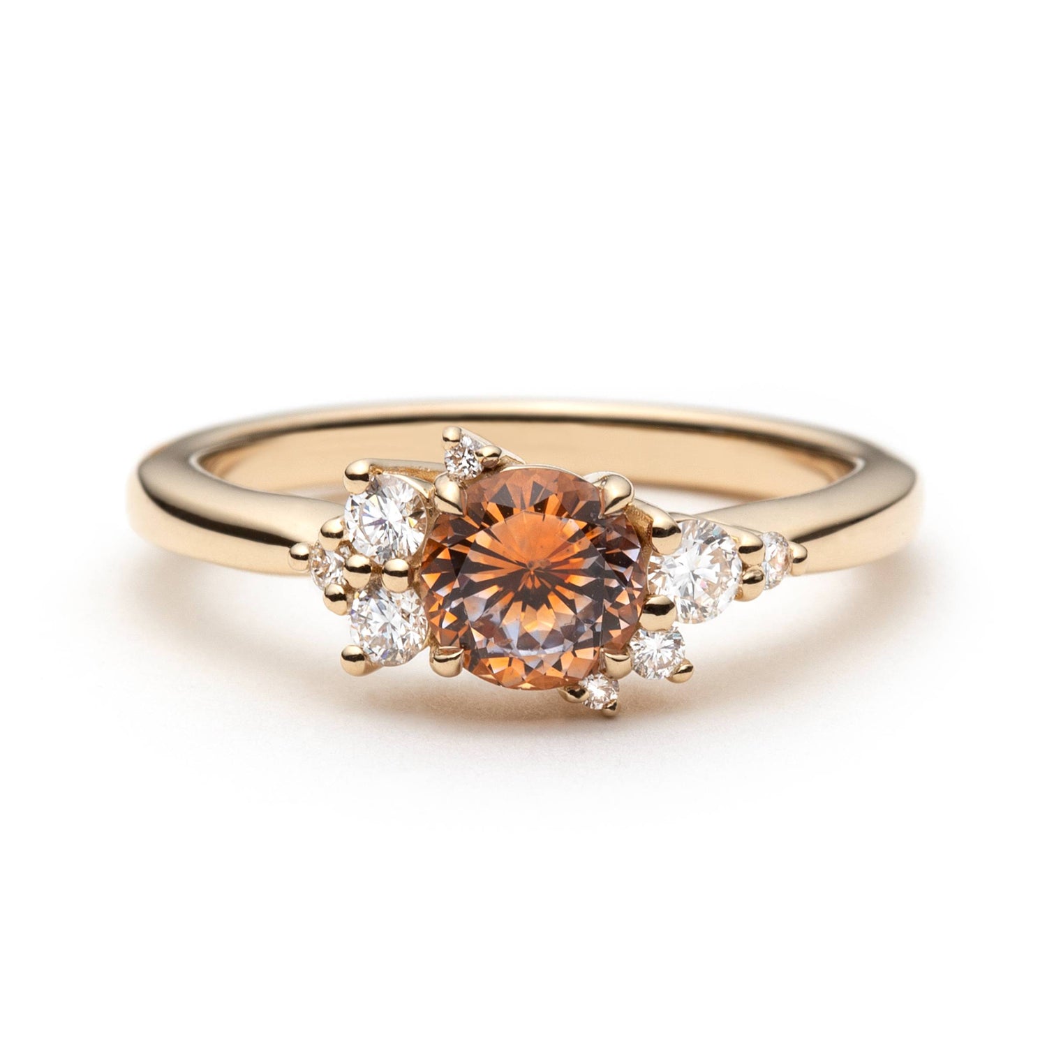 0.82ct round orange-pink Montana sapphire and diamond cluster engagement ring in 14k yellow gold, front view showing asymmetric diamond setting