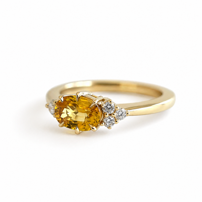 Bague de fiançailles en saphir jaune vif ovale et diamants en or jaune 14k, vue en angle montrant les accents de diamants asymétriques