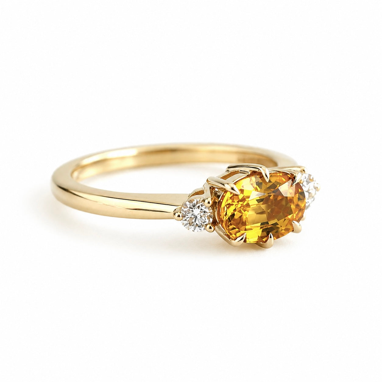 Bague de fiançailles en saphir jaune vif ovale et diamants en or jaune 14k, vue de côté montrant le profil du corps de bague et le détail du serti, sur fond blanc