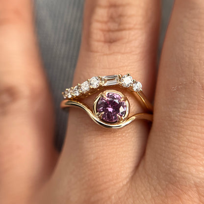 Pink sapphire solitaire ring in 14k yellow gold, styled with matching diamond wedding band, worn on hand