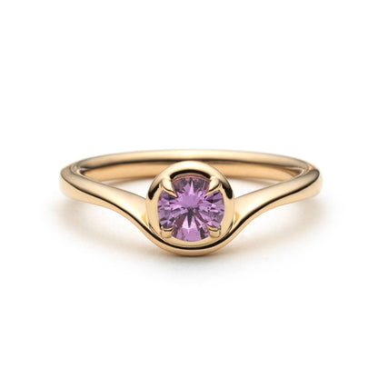 Pink sapphire solitaire ring in 14k yellow gold, front view showing wave setting