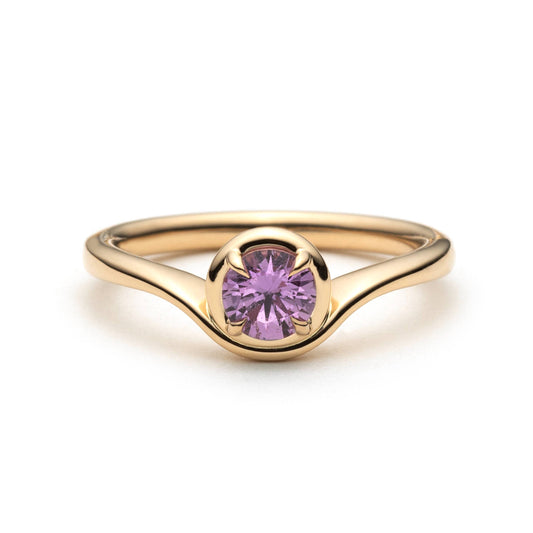 Pink sapphire solitaire ring in 14k yellow gold, front view showing wave setting