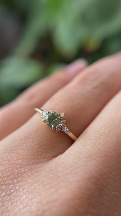 0.36ct round bi-color yellow to blue sapphire and natural diamond constellation engagement ring in 14k yellow gold, worn on finger showing gemstone colour shift and diamond cluster detail