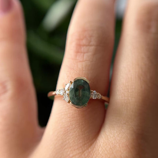 Oval green sapphire and natural diamond asymmetrical ring. The video shows the array of color from the center stone, and the sparkling side diamonds.  