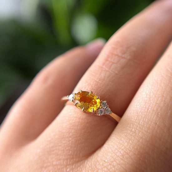 1.05ct oval bright yellow Sri Lankan sapphire and diamond ring in 14k yellow gold, worn on hand showing stone colour and asymmetric diamond accents in motion
