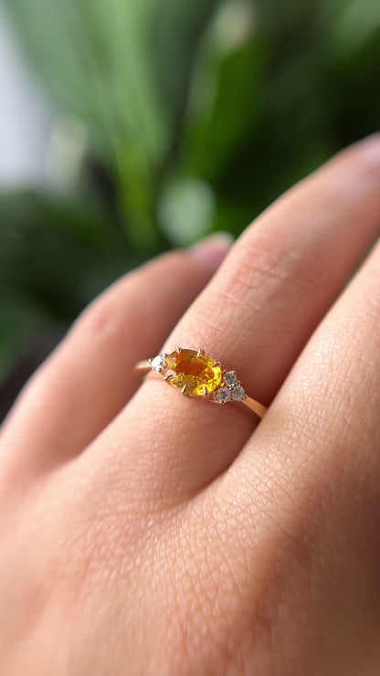 1.05ct oval bright yellow Sri Lankan sapphire and diamond ring in 14k yellow gold, worn on hand showing stone colour and asymmetric diamond accents in motion