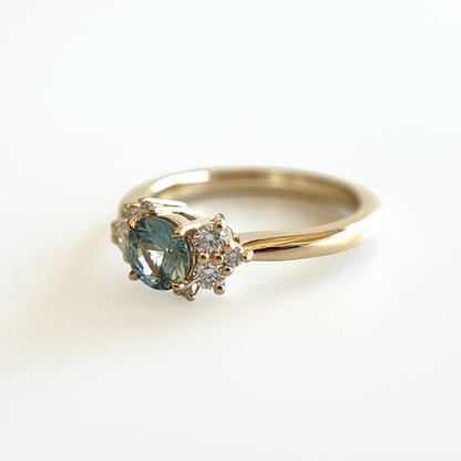 Bague de fiançailles en saphir sarcelle et diamants en or jaune 14k, vue en angle montrant le serti asymétrique