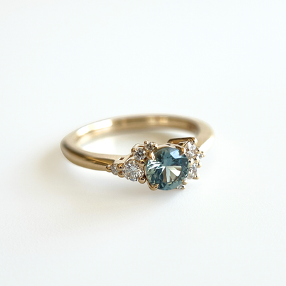 Bague de fiançailles en saphir sarcelle et diamants en or jaune 14k, vue de côté montrant le serti asymétrique