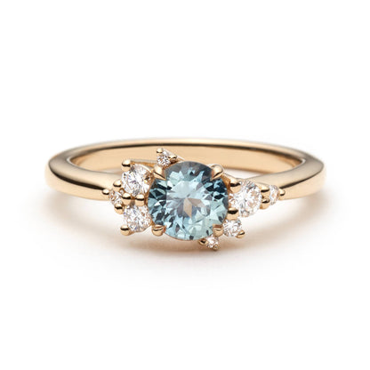 Bague de fiançailles en saphir sarcelle rond non chauffé de 0,68ct et diamants en or jaune 14k, vue de face montrant le serti asymétrique