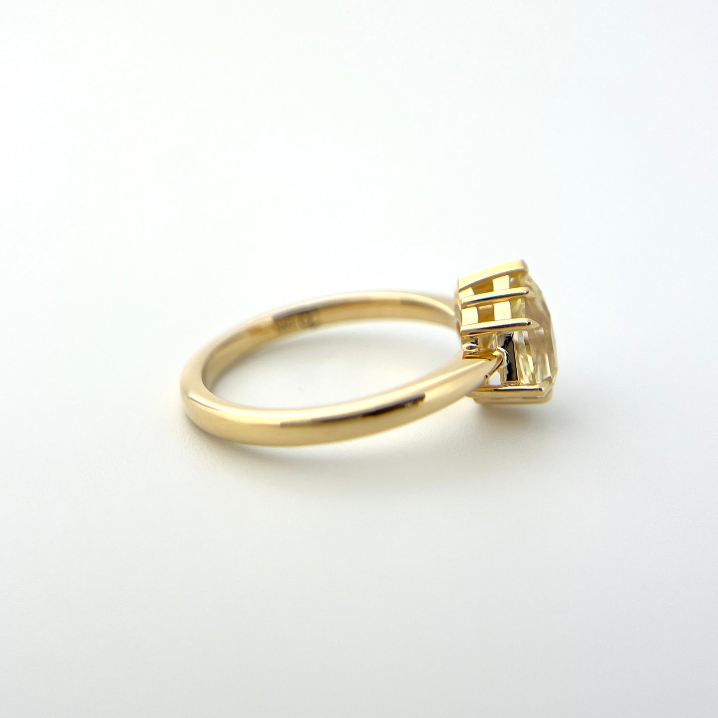 1.07ct shield cut light yellow Sri Lankan sapphire and diamond ring in 18k yellow gold, profile view showing band width and setting height