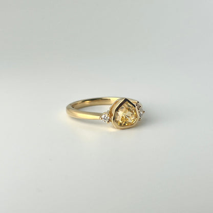 1.18ct mixed-cut trillion shaped bright yellow Sri Lankan sapphire and diamond ring in 18k yellow gold, angled view showing bezel setting and band detail