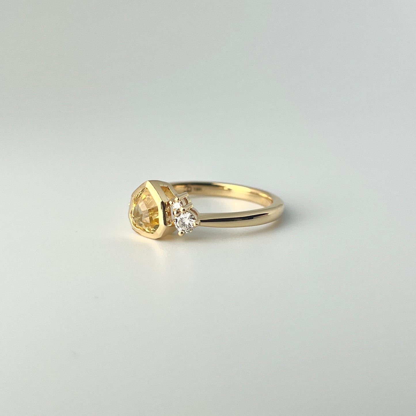 1.18ct mixed-cut trillion shaped bright yellow Sri Lankan sapphire and diamond ring in 18k yellow gold, side view showing bezel setting and band profile